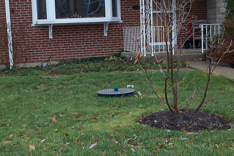 Photo of the lid of a backup prevention device in a front yard