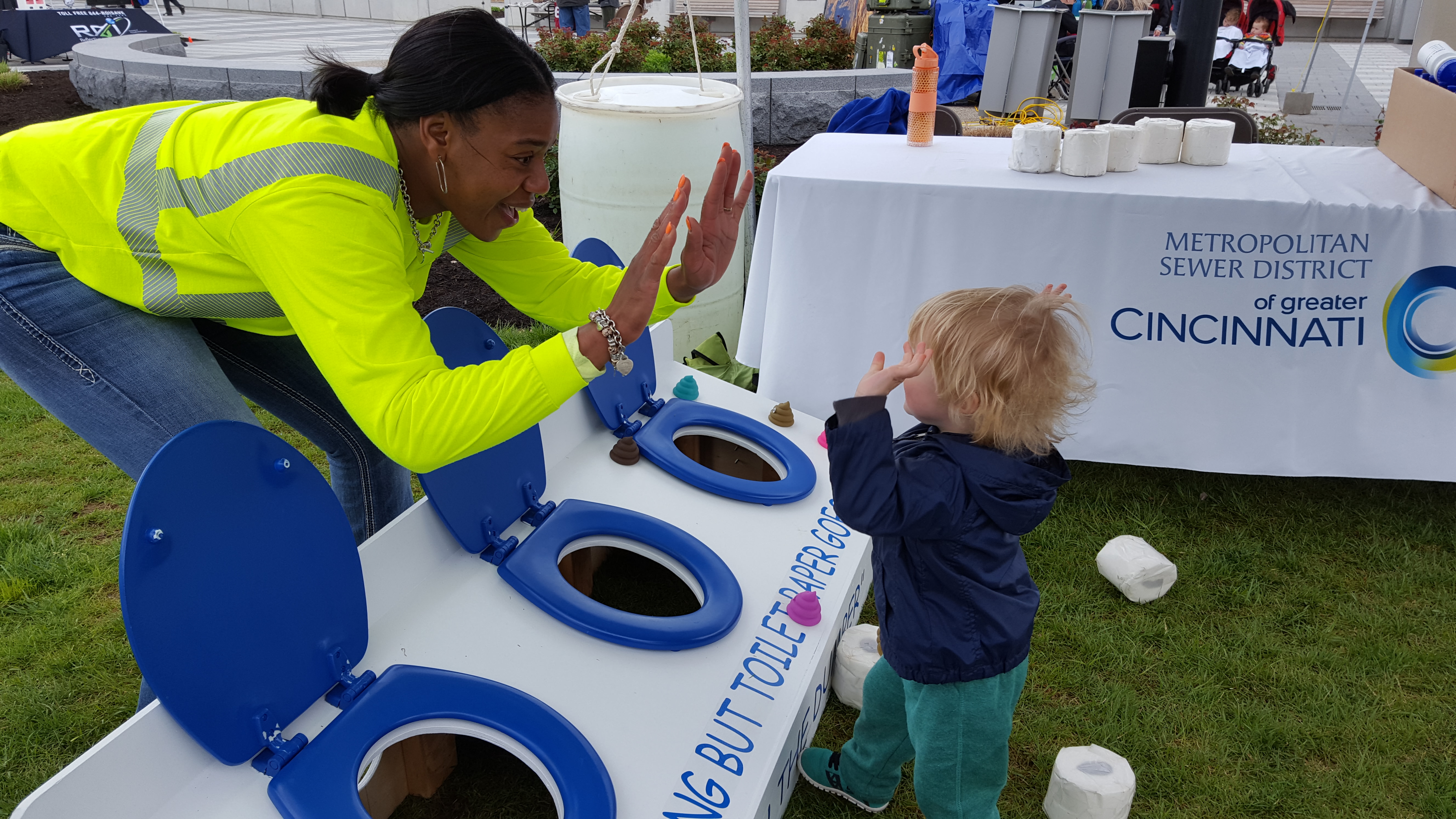 Photo of MSD employee high fiving a small child during the Earth Day 2017 celebration in Blue Ash 
