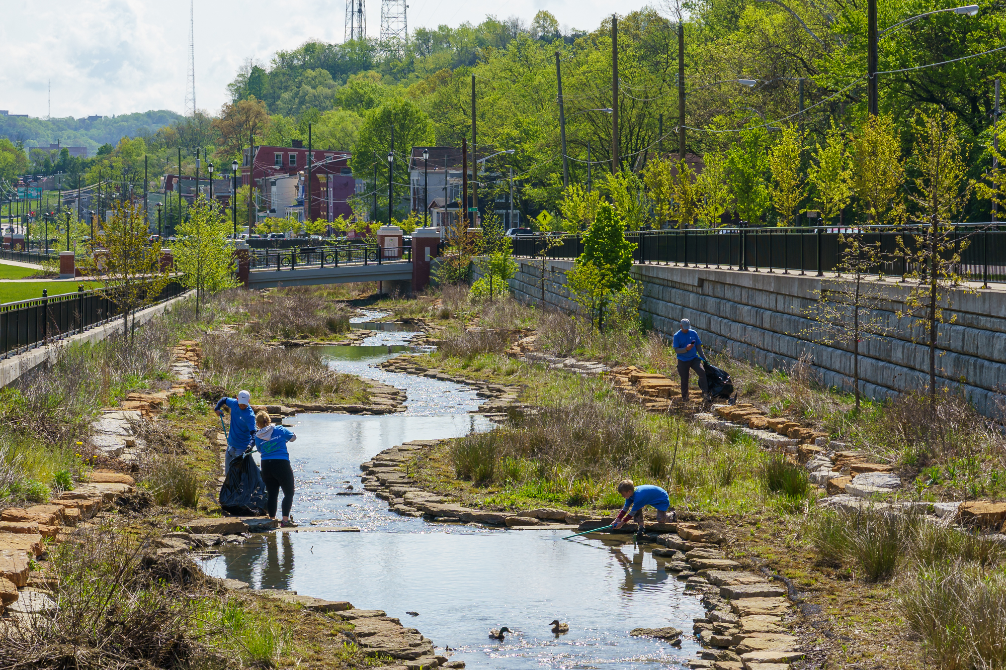 Photo people cleaning up trash from the Lick Run Greenway stream channel