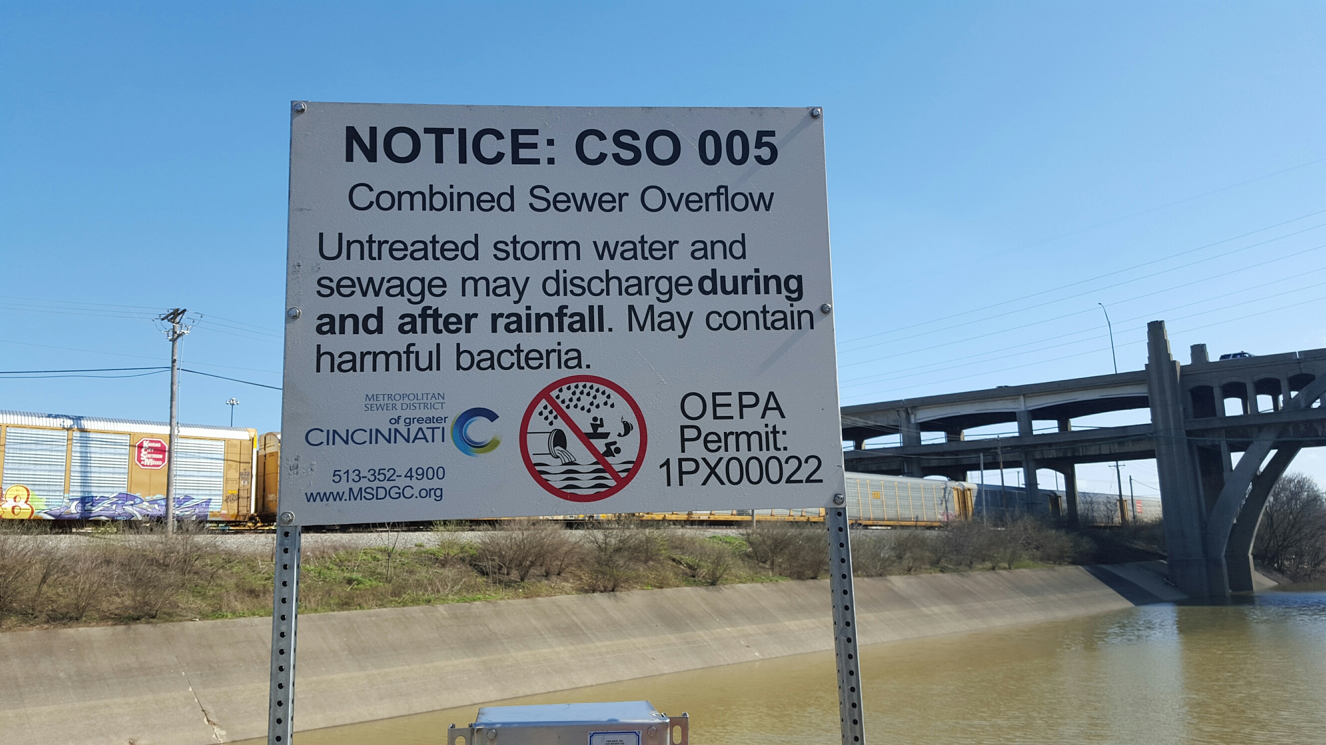 Photo of the CSO 5 outfall sign on the Mill Creek (wiht the Ohio EPA permit number)